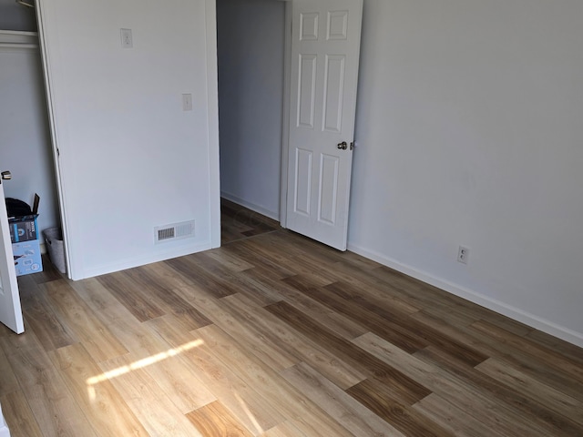 unfurnished bedroom with hardwood / wood-style floors and a closet