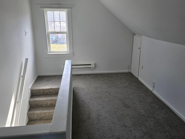 additional living space with dark colored carpet, lofted ceiling, and baseboard heating