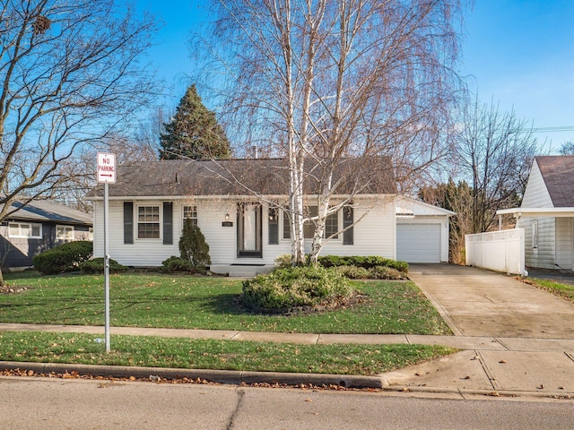 single story home featuring a front yard, a garage, and an outbuilding