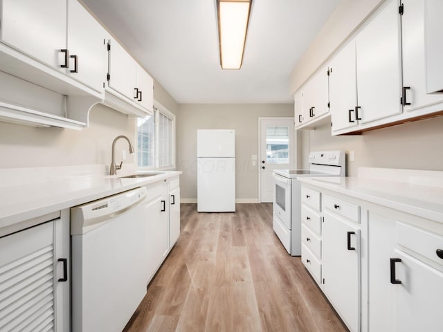 kitchen with white appliances, light hardwood / wood-style floors, white cabinetry, and sink