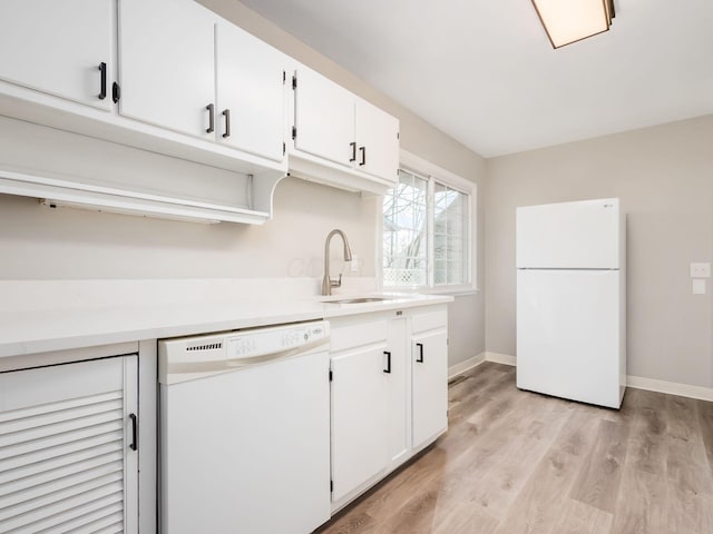 kitchen with white appliances, light hardwood / wood-style flooring, white cabinetry, and sink