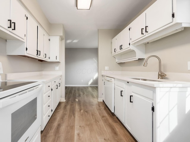 kitchen featuring sink, white appliances, light wood-type flooring, and white cabinets