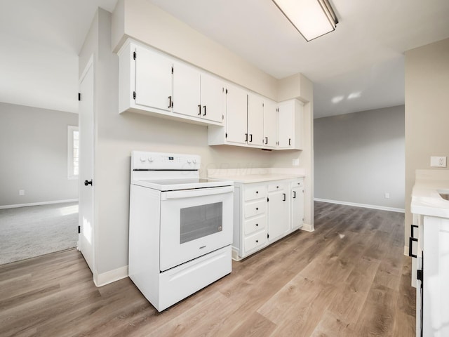 kitchen featuring white cabinets, light hardwood / wood-style floors, and white electric range