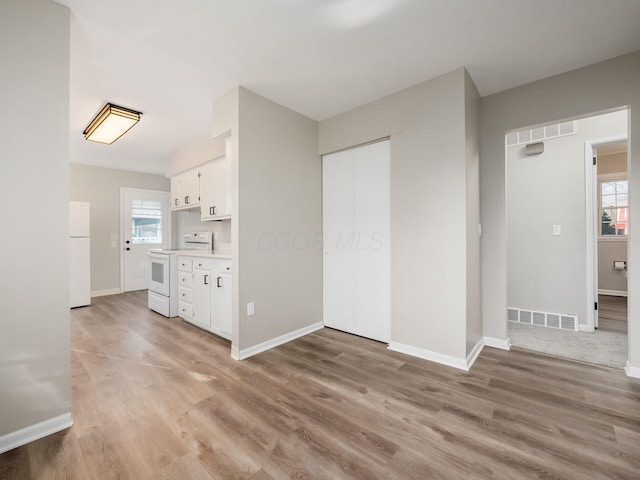 unfurnished living room featuring light wood-type flooring and a wealth of natural light