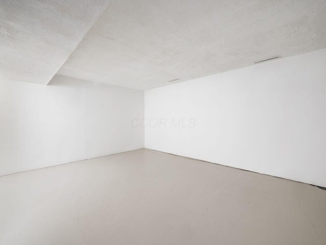 empty room featuring a textured ceiling and concrete flooring