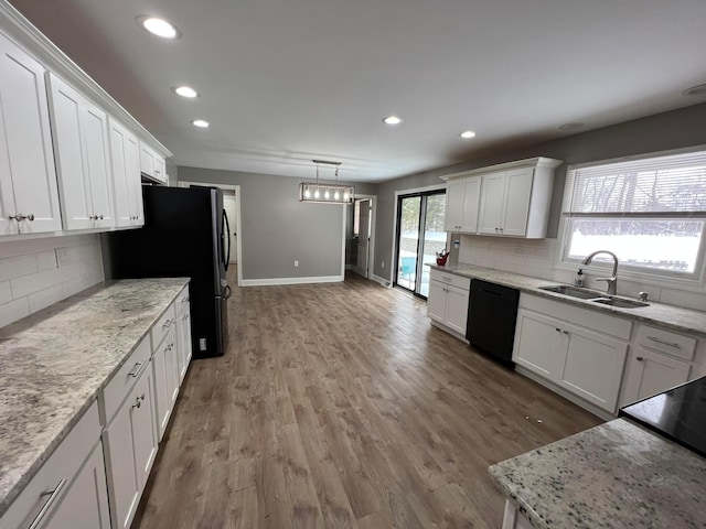 kitchen with black appliances, decorative backsplash, and white cabinetry