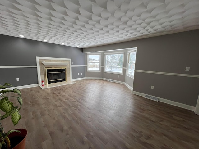 unfurnished living room with a high end fireplace and hardwood / wood-style flooring