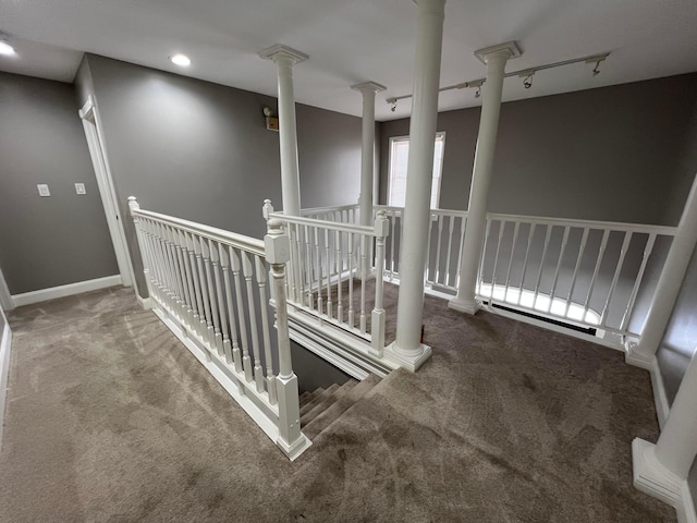 stairs with carpet flooring and track lighting