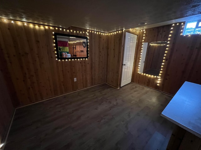 unfurnished room with hardwood / wood-style floors and wooden walls