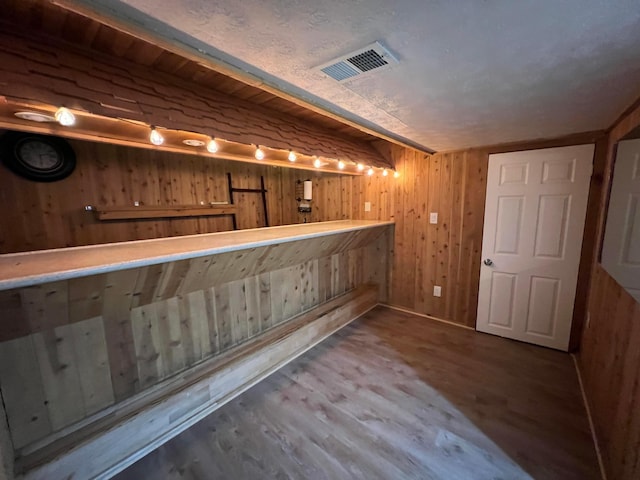 bar featuring wooden walls and hardwood / wood-style floors