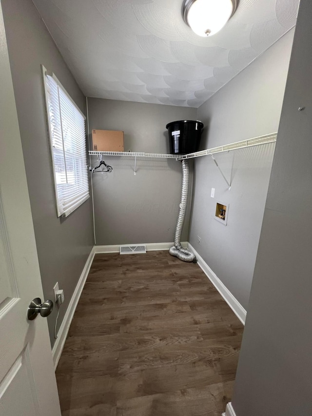 clothes washing area with hookup for a washing machine and dark hardwood / wood-style flooring