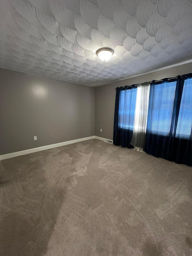 empty room featuring carpet flooring and a textured ceiling