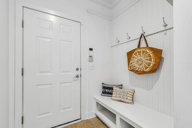 mudroom with light tile patterned floors and crown molding