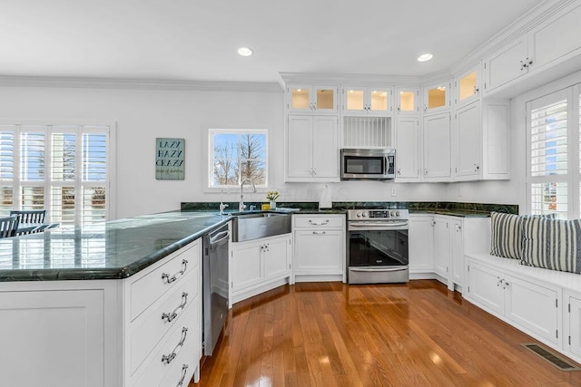 kitchen featuring kitchen peninsula, stainless steel appliances, and white cabinets