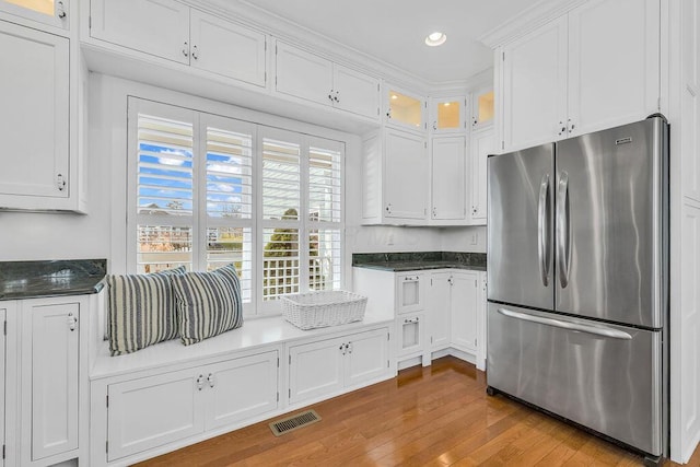 kitchen featuring stainless steel refrigerator, white cabinetry, and light hardwood / wood-style flooring