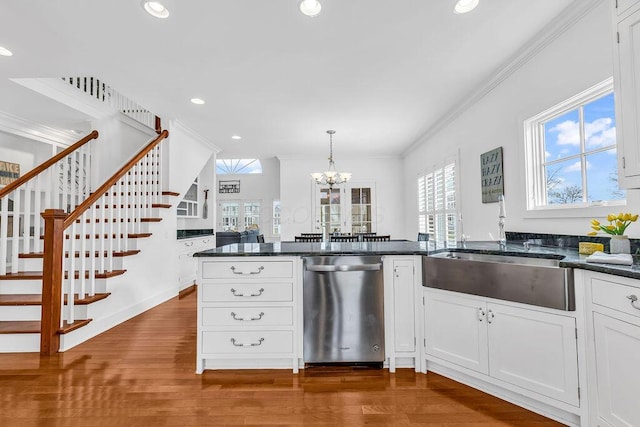 kitchen featuring dishwasher, white cabinetry, hanging light fixtures, and a wealth of natural light