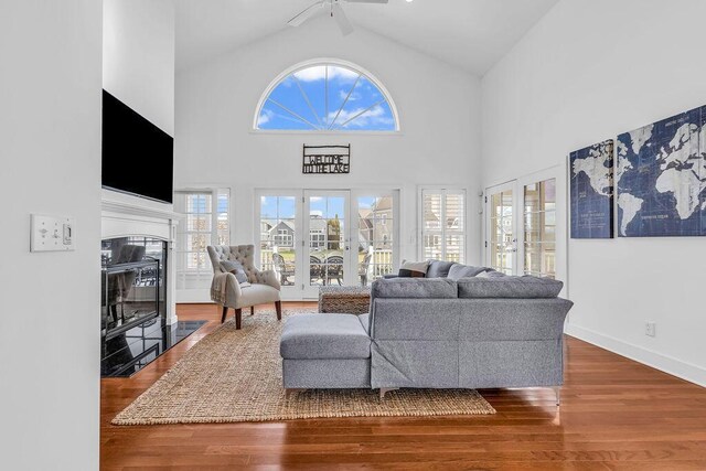 living room with hardwood / wood-style flooring, ceiling fan, a wealth of natural light, and high vaulted ceiling