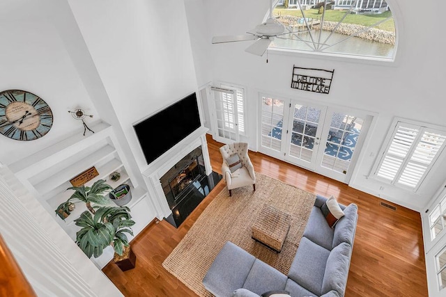 living room featuring a high ceiling, a wealth of natural light, and wood-type flooring