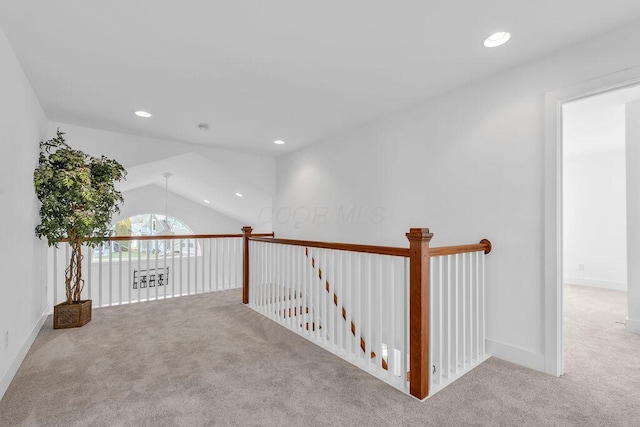 hall featuring light colored carpet and lofted ceiling