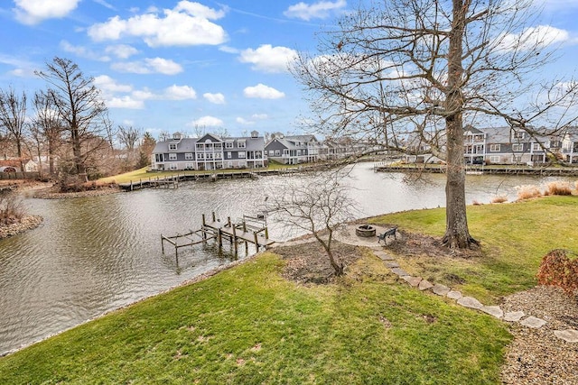 dock area featuring a yard, a water view, and a fire pit