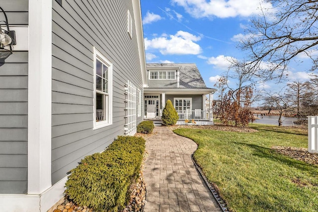 view of side of property with a yard and covered porch