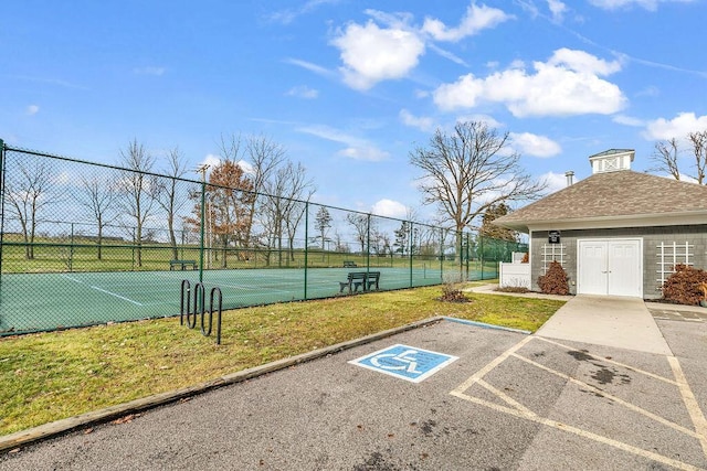 view of property's community with a yard and tennis court