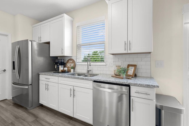 531 White Fawn Run, Delaware, OH 43015 - kitchen with appliances with stainless steel finishes, a sink, decorative backsplash, white cabinetry, and wood finished floors