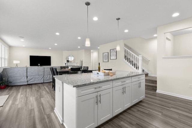 531 White Fawn Run, Delaware, OH 43015 - kitchen with wood finished floors, a kitchen island, white cabinetry, light stone countertops, and recessed lighting