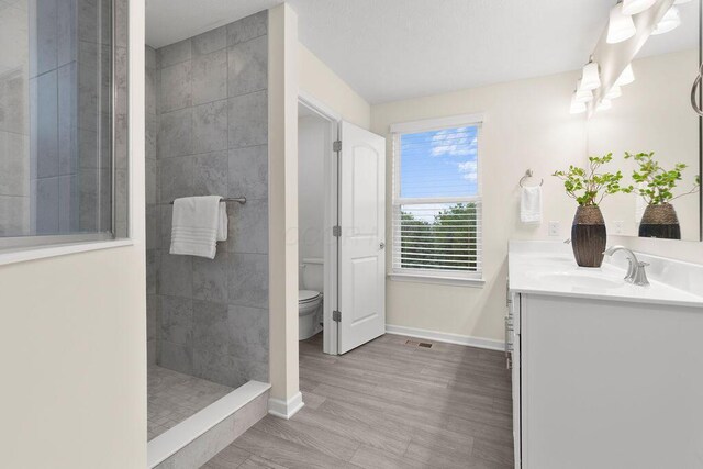 531 White Fawn Run, Delaware, OH 43015 - bathroom featuring toilet, walk in shower, double vanity, baseboards, and wood finished floors