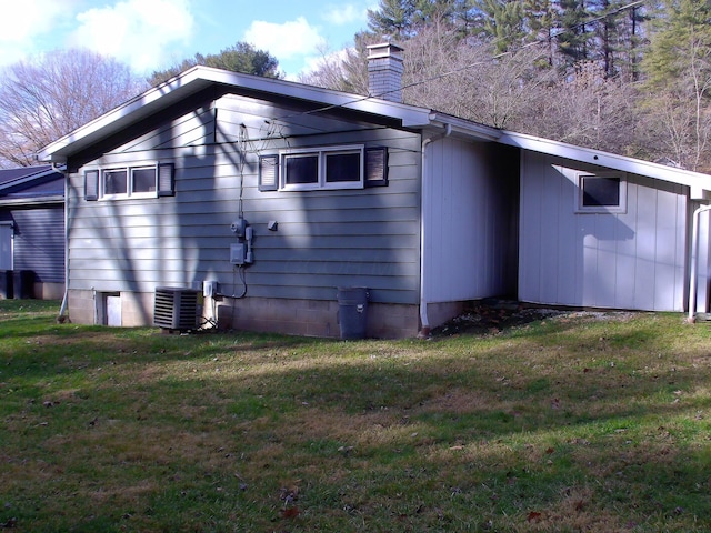 view of property exterior with a lawn and central AC