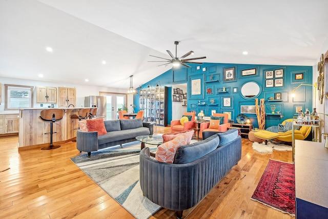 living room with ceiling fan, light hardwood / wood-style flooring, and lofted ceiling