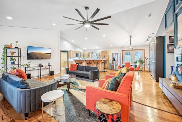 living room with ceiling fan, light hardwood / wood-style flooring, high vaulted ceiling, and french doors