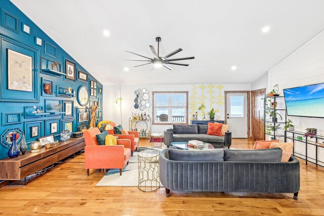 living room featuring light hardwood / wood-style flooring, vaulted ceiling, and ceiling fan