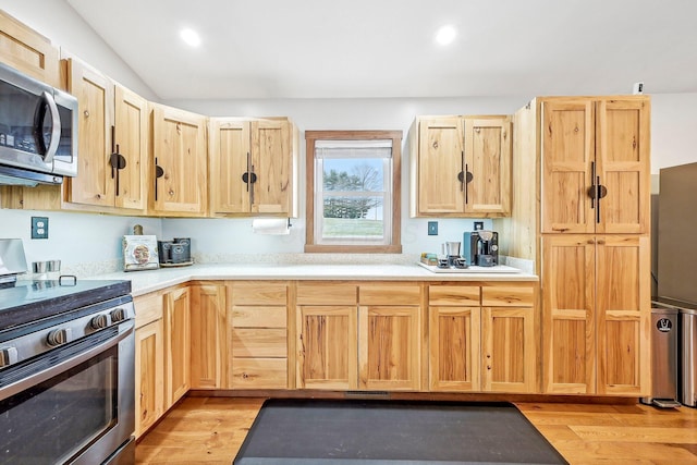 kitchen featuring light brown cabinetry, appliances with stainless steel finishes, and light hardwood / wood-style flooring