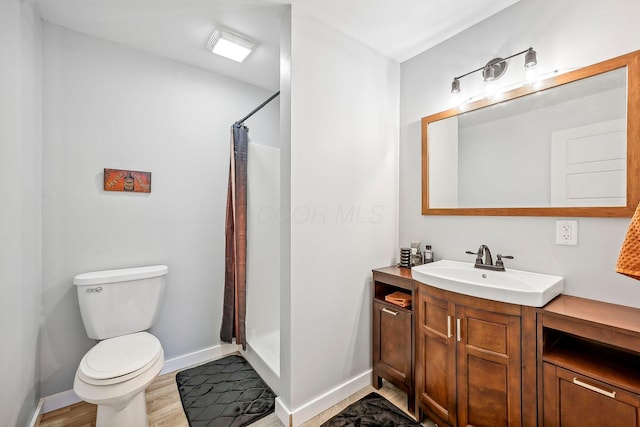 bathroom with wood-type flooring, vanity, toilet, and walk in shower