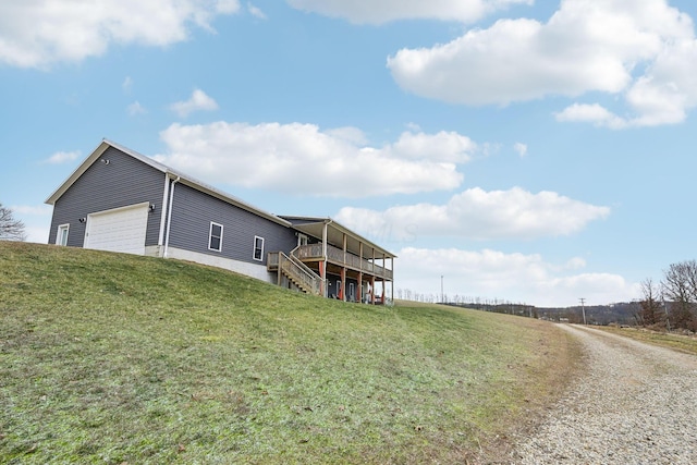 exterior space with a garage, a yard, and a deck