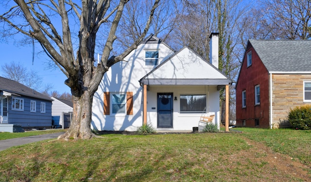 view of front of property featuring covered porch and a front lawn