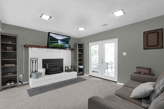 carpeted living room with a wood stove and french doors