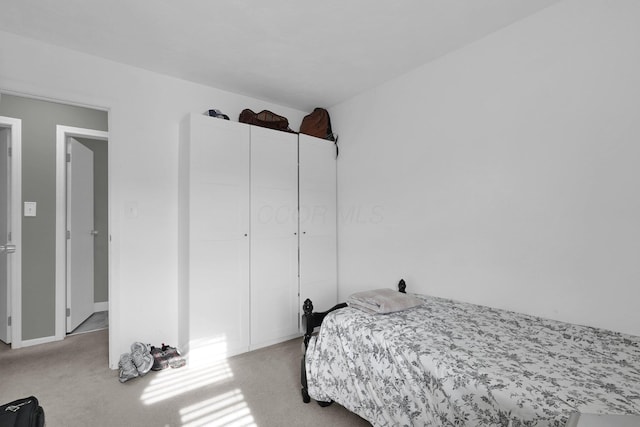 bedroom with light carpet and a closet