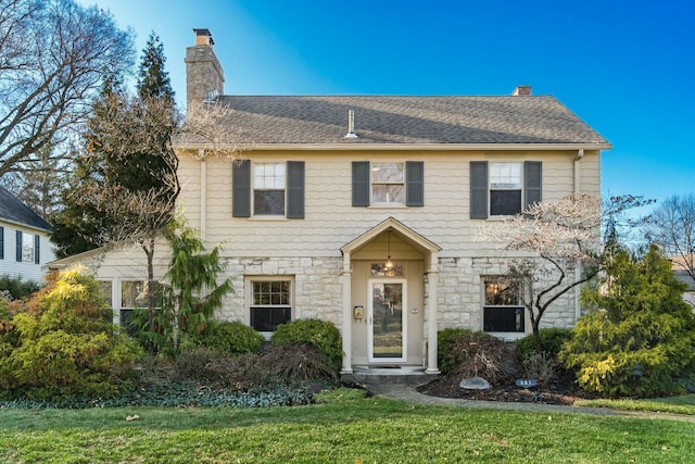 colonial house featuring a front lawn