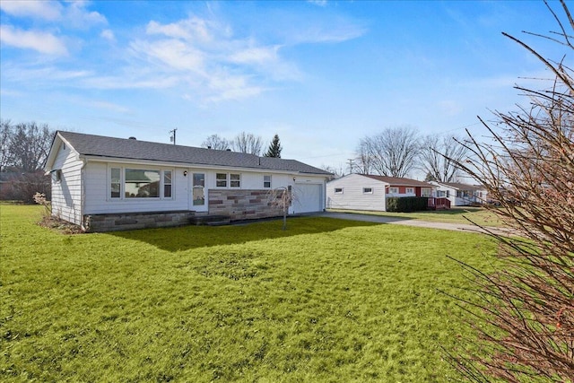 rear view of house featuring a lawn and a garage