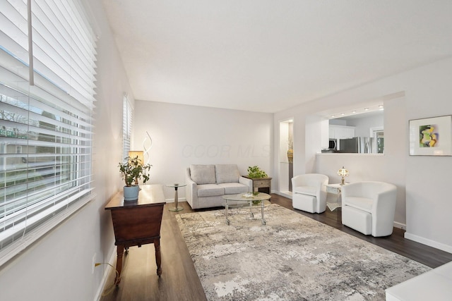 living room with a healthy amount of sunlight and dark hardwood / wood-style flooring