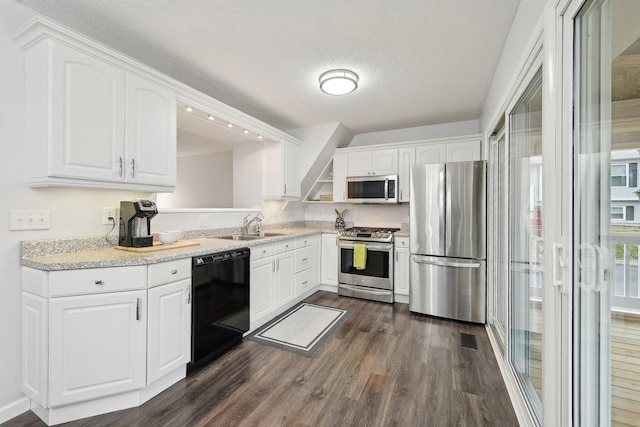 kitchen featuring dark wood-type flooring, appliances with stainless steel finishes, sink, and white cabinets