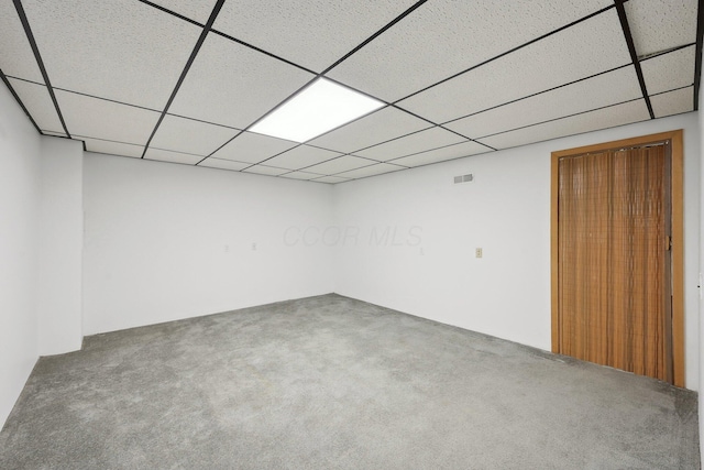 basement featuring a paneled ceiling and carpet flooring