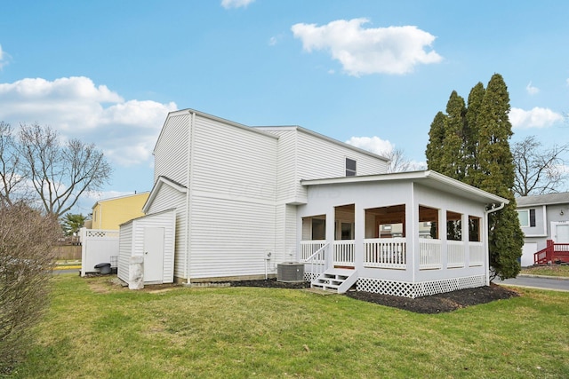 rear view of property featuring a porch, cooling unit, and a lawn