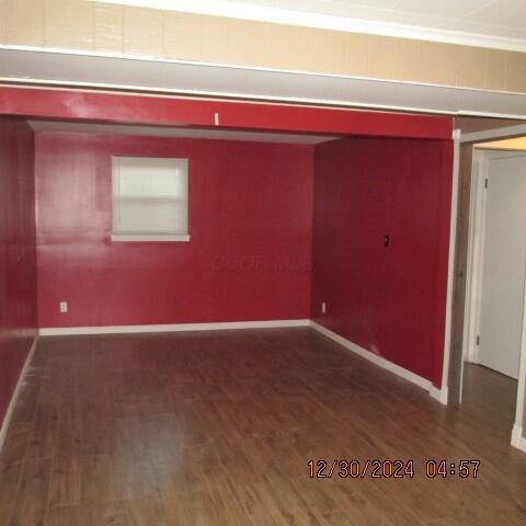 unfurnished room with dark wood-type flooring