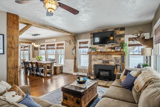 living room featuring dark hardwood / wood-style floors, a wood stove, and ceiling fan