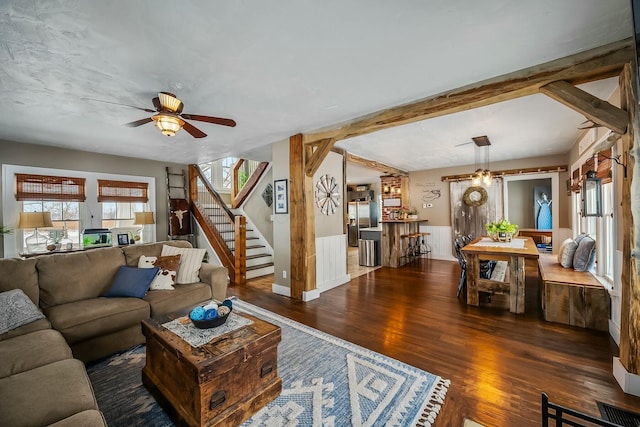 living room with a healthy amount of sunlight, ceiling fan, and dark wood-type flooring