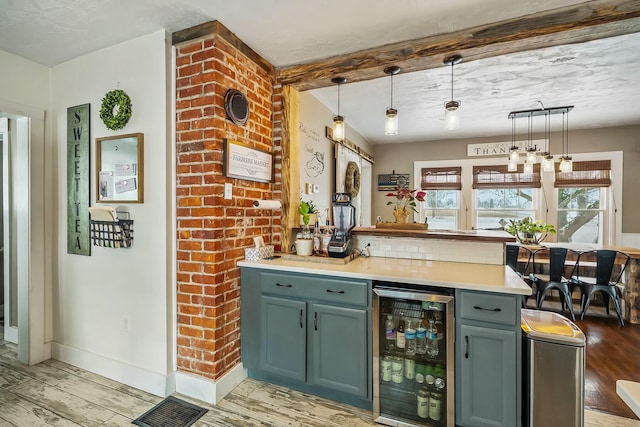 bar with light hardwood / wood-style flooring, beverage cooler, and decorative light fixtures