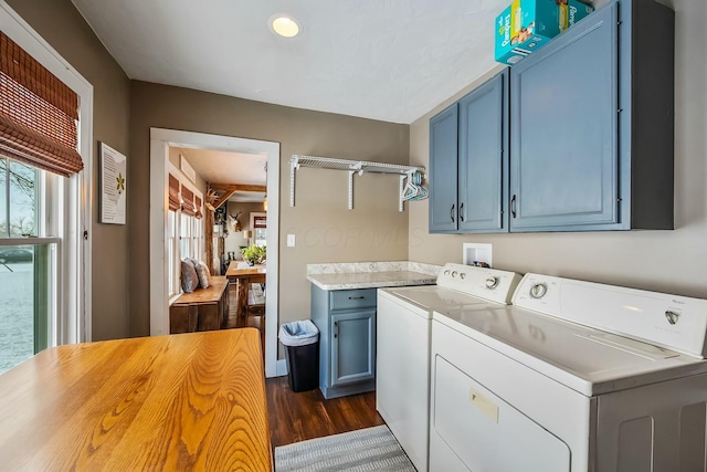 washroom with dark hardwood / wood-style flooring, plenty of natural light, cabinets, and independent washer and dryer